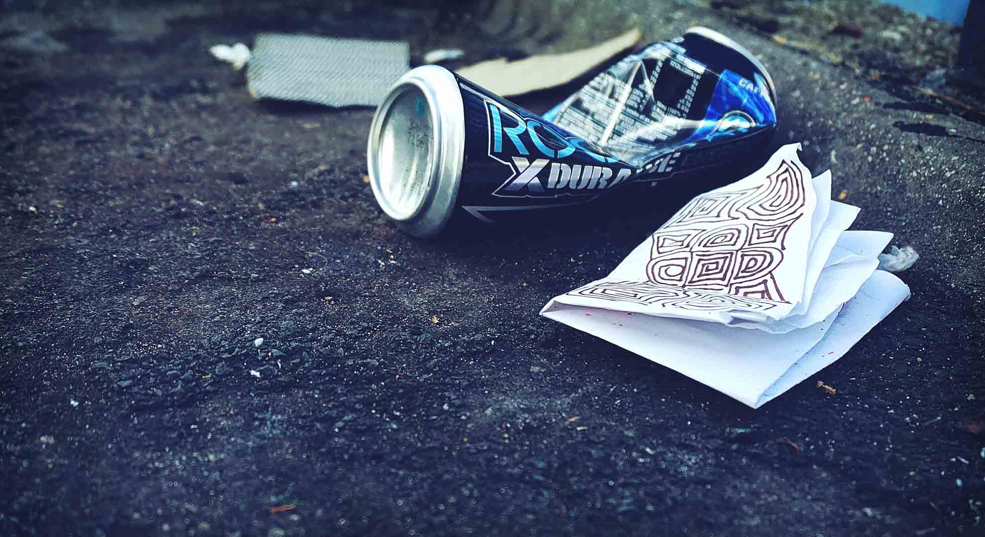 image of can and napkin littered on the street