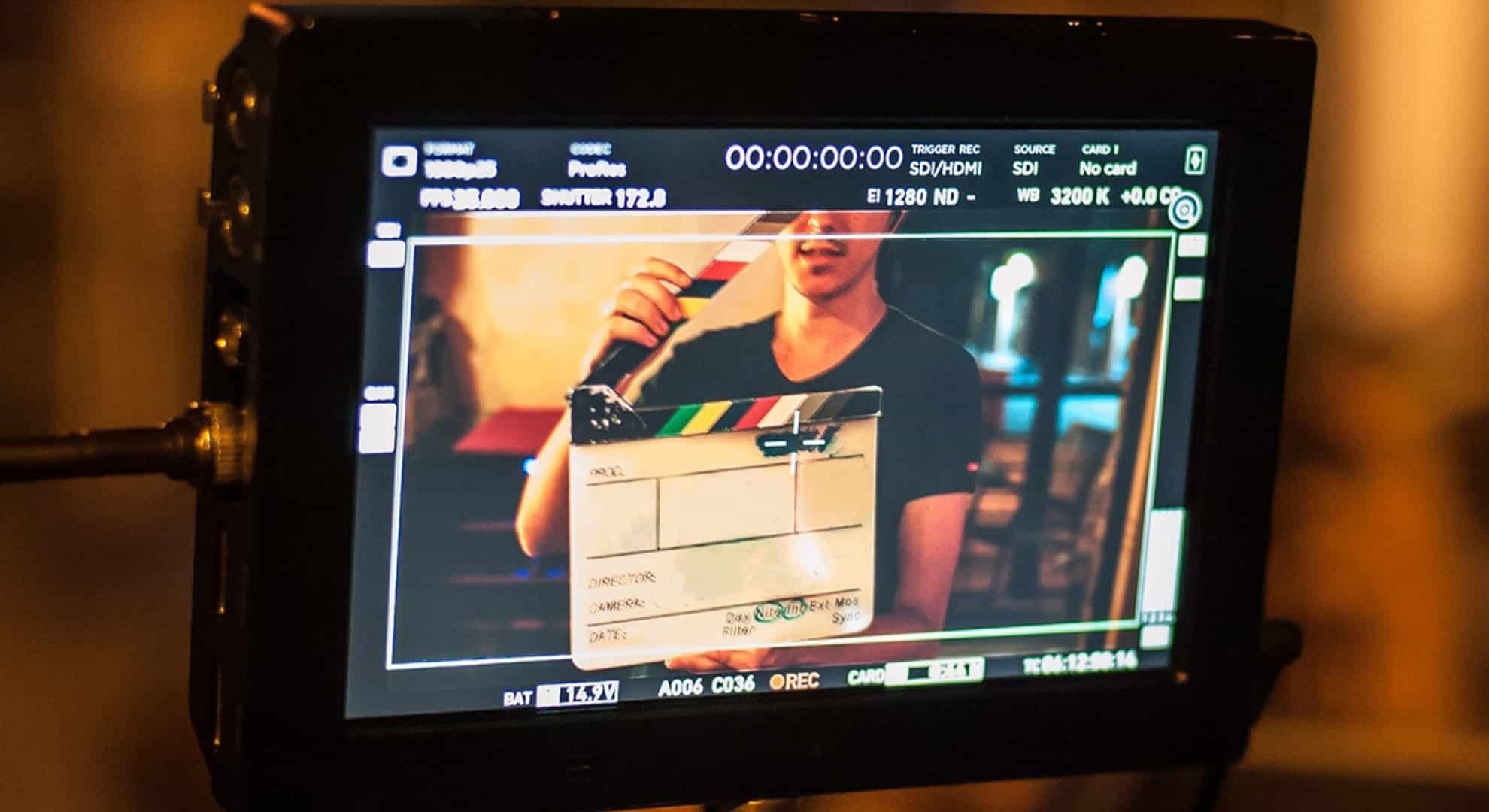 Filming on location. Man holding a clapper board in front of the camera, the filming process. 