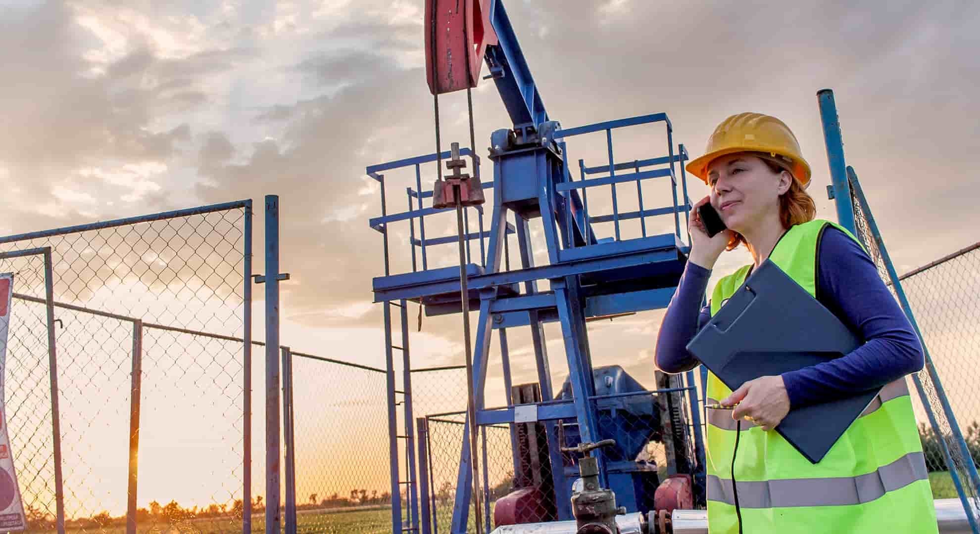 Woman engineer at oil field making a phone call