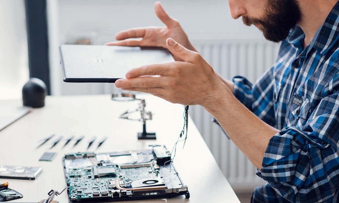 Photo of a man taking apart a laptop to repair it.jpeg