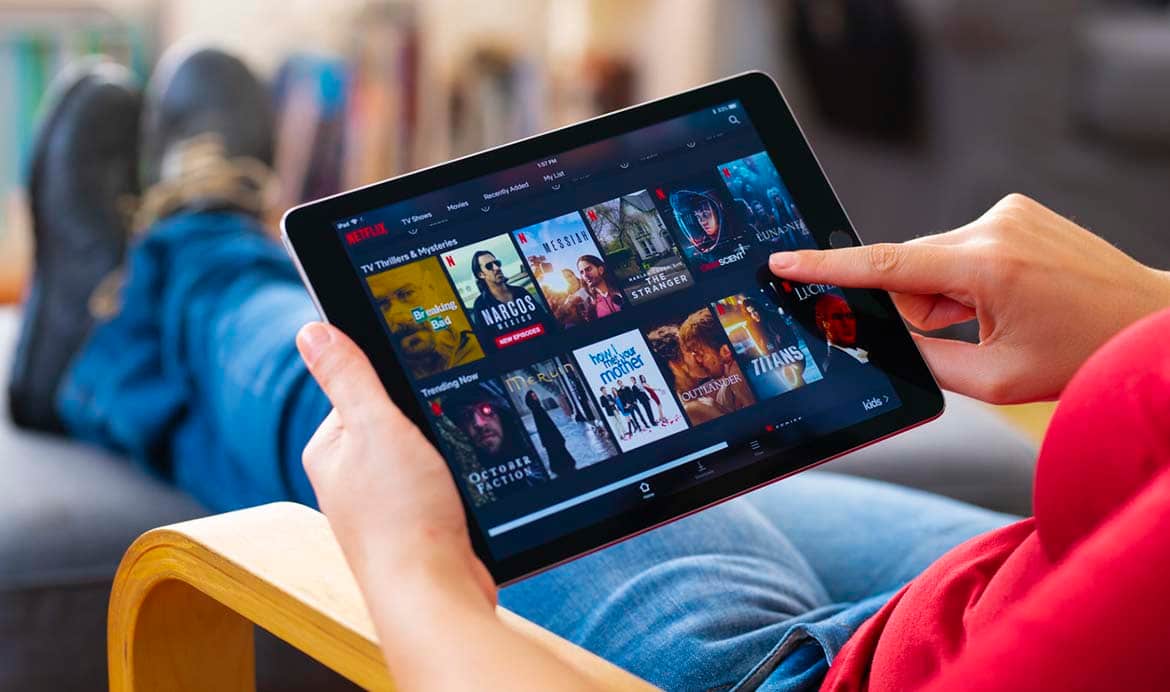 Photo of a person scrolling through netflix on a tablet
