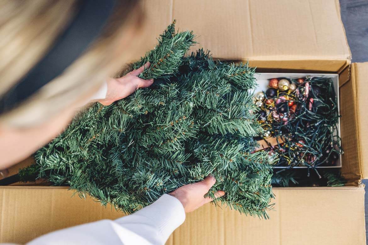 packing artificial tree away in a cardboard box