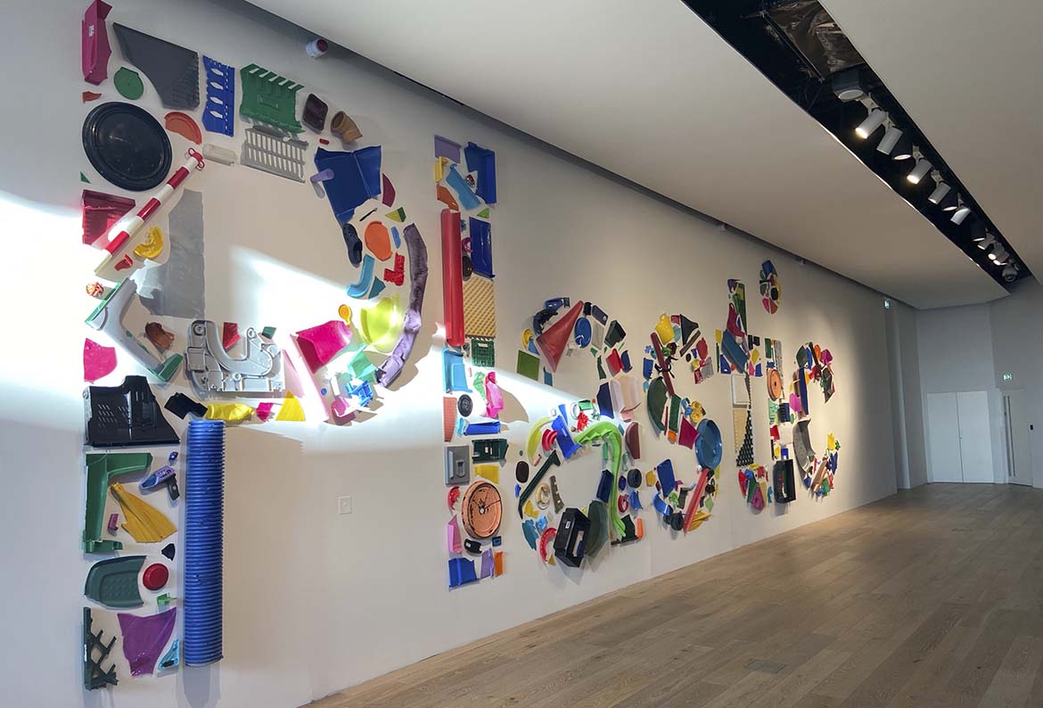 The word plastic made from plastic items on a wall