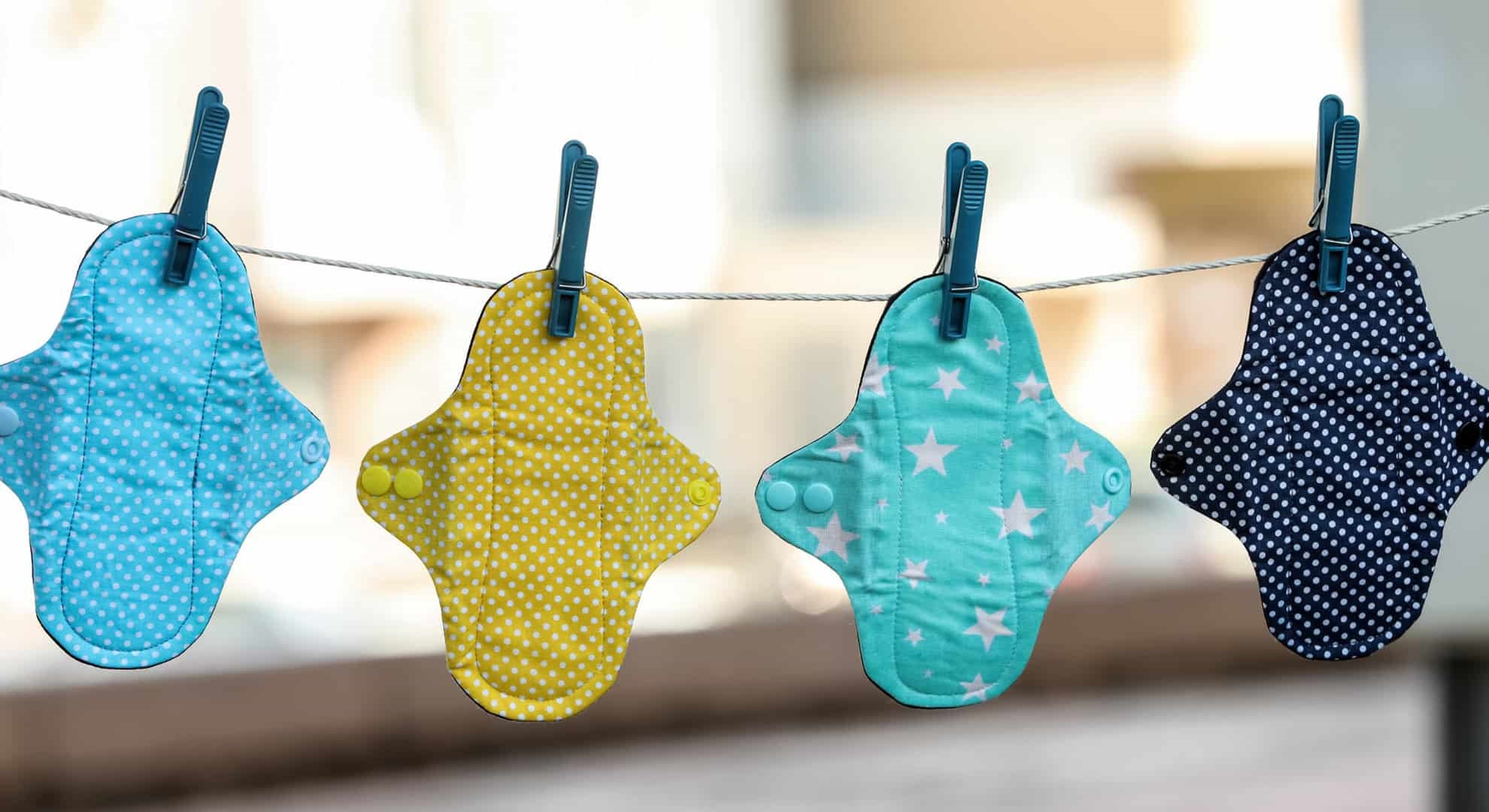 Many different menstrual cloth pads hanging on rope outdoors