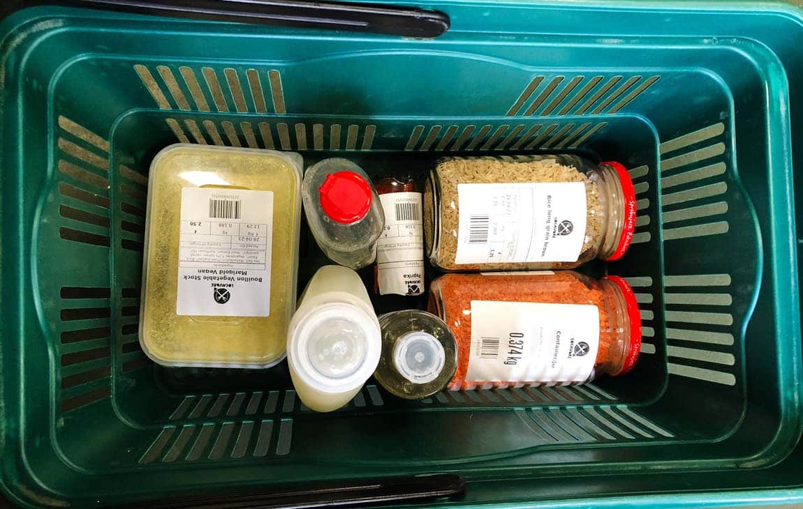 Photo of a shopping basket with filled containers at a zero waste refill store