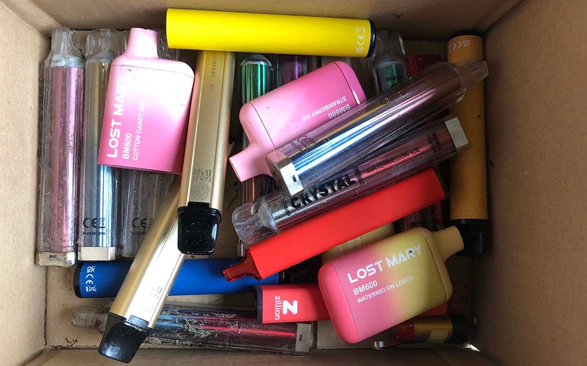 Photo of a cardboard box full of disposable vapes collected on a litter pick