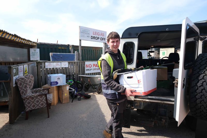 male dropping of used goods at reuse site 