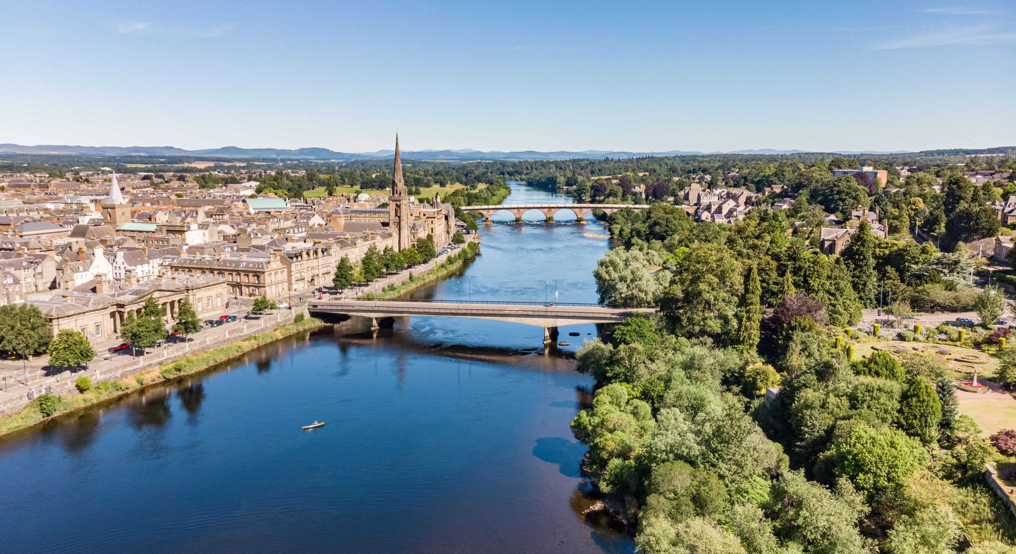 Scenic image of Perth and Kinross town centre including a river and greenery